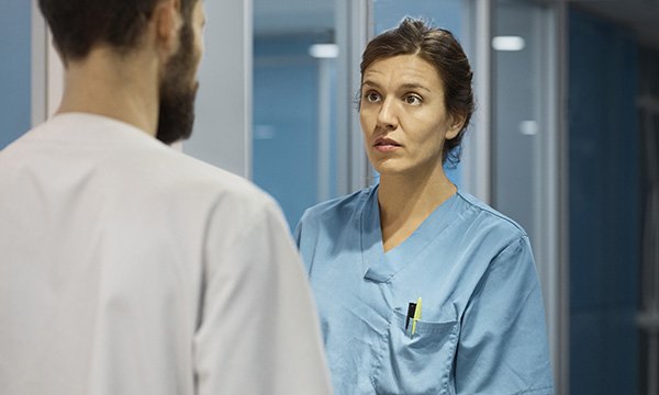 Dismayed looking nurse talking to a colleague in a corridor. Picture: iStock
