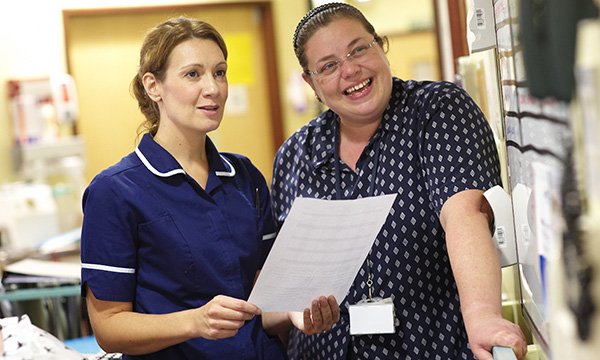two nurses talk happily on the ward
