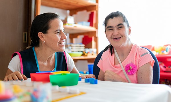 Picture shows mental health professional sitting at a table with a woman with Down’s syndrome woman. A national framework in Ireland aims to provide person-centred services for people with learning disabilities and their families and carers.