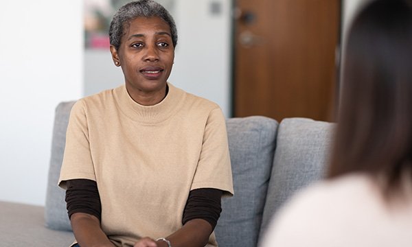 Picture shows an older woman talking to a therapist. A new study shows the wider lifestyle benefits associated with PBS-based approaches and the need to capitalise on these gains.