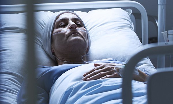 Picture shows woman cancer patient lying in a hospital bed.