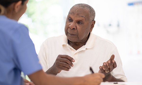Man who has prostate cancer sits talking to nurse