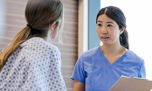 Photo of nurse talking to female patient, illustrating story that nurses should be allowed to perform early-stage abortions