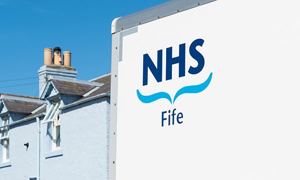 Sign for NHS Fife premises with blue sky and partial street scene in background. Hospital in NHS at centre of patient information breach