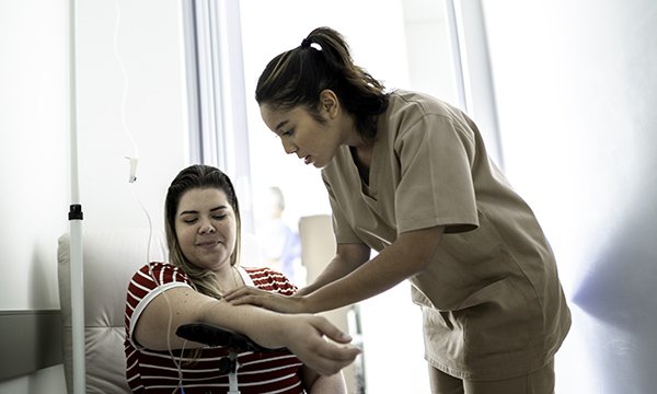 A nursing associate prepares a female patient for a vaccination