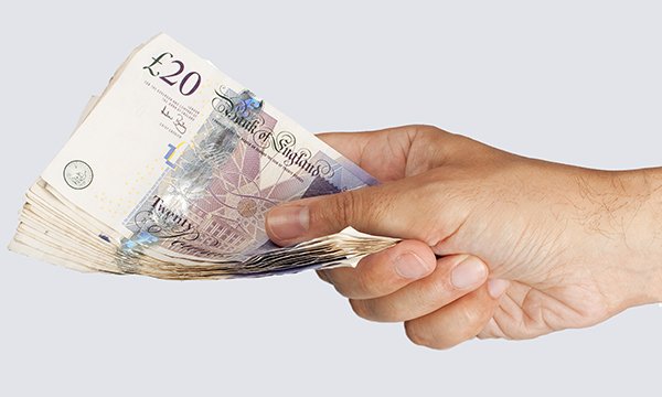 Image showing a close-up of a person's hand holding £20 notes, suggesting nurses' pay rise