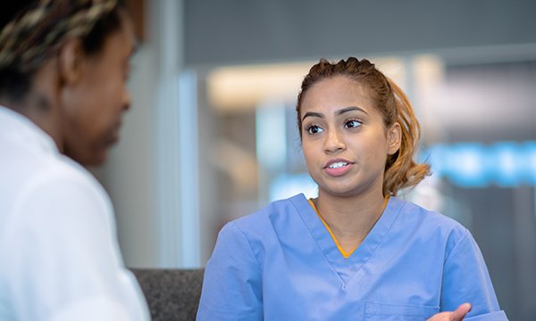 A nurse appears apprehensive while being questioned by a senior nurse